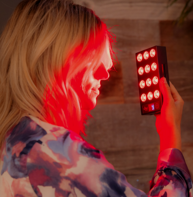A woman using red light therapy for brain fog.