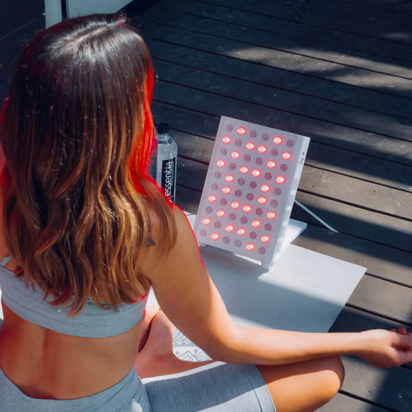 A Woman using her Vital Pro red light therapy device to combat sun damage to her skin