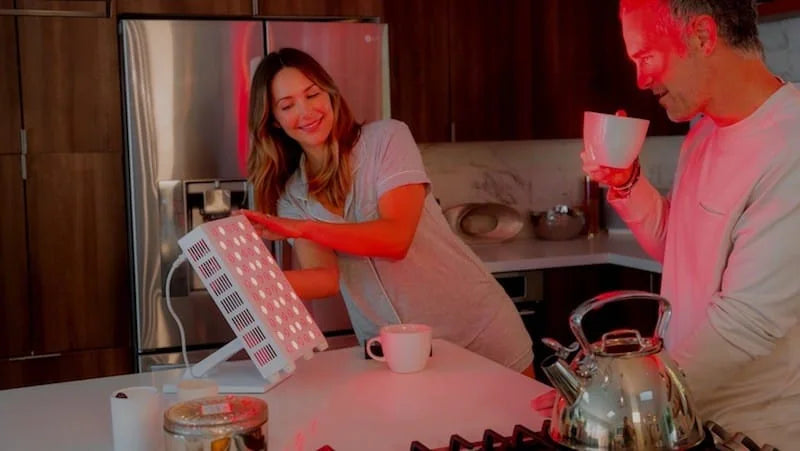 Woman using a Vital Pro red light therapy device for exercise recovery after workout