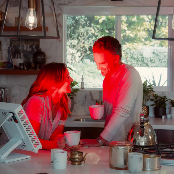 A couple enjoying coffee while using their Vital Pro red light therapy device