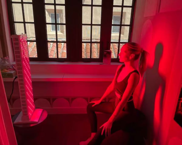 Woman meditating in front of red light therapy