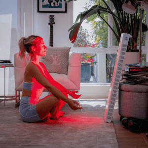 Woman meditating in front of red light therapy